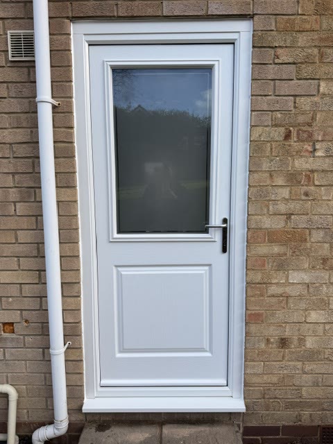 White uPVC half-glazed back door in a brick wall