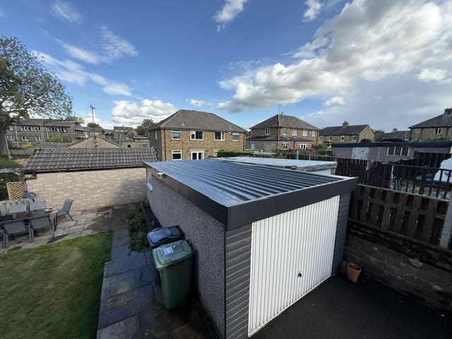 The same roof replaced with anthracite box-profile sheet and a new fascia