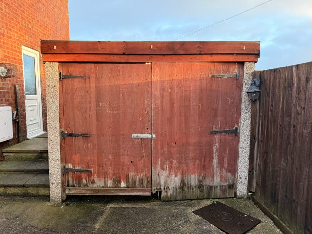Weathered red timber side-hinged garage doors