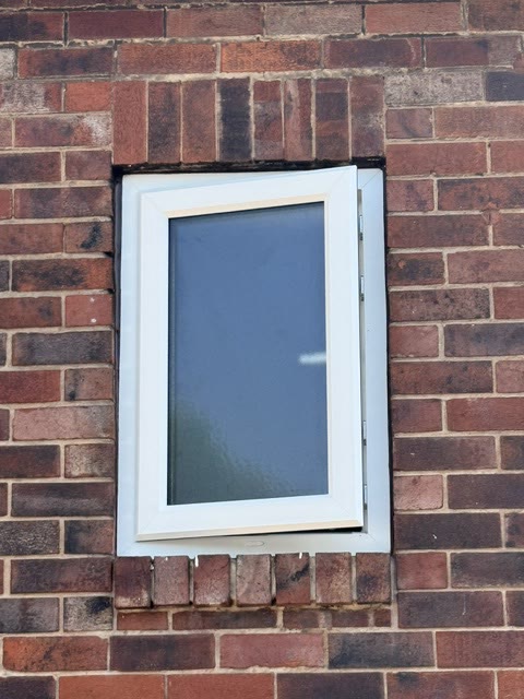 New white uPVC casement window with obscure glazing, open on its hinges